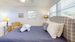 A hotel room with a bed, a ceiling fan, a window, a chair, and a lamp. - Barrett's Watch Main House- Oceanfront on Lobster Cove with deck & shared firepit - walk to town (Boothbay Harbor)