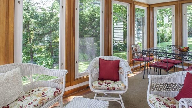 A room with wicker furniture, large windows, and a view of greenery. - Great home with water view - one house from harbor - washer/dryer & dog-friendly (Camden)