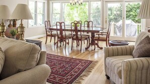 A dining area with a table and chairs, a chandelier, and a view through large windows. - Great home with water view - one house from harbor - washer/dryer & dog-friendly (Camden)