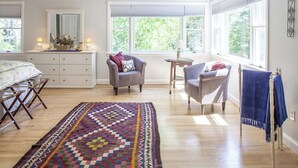 A bedroom with a bed, two chairs, a small table, a dresser, and a large window. - Great home with water view - one house from harbor - washer/dryer & dog-friendly (Camden)