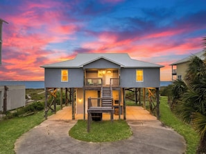 A two-story house with a balcony, a staircase leading to the upper floor, and a view of the ocean. - Beach House - Mutual Fun (Port St. Joe)