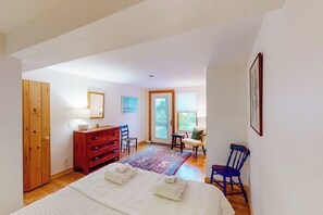 Une chambre à coucher avec un lit, une armoire en bois, un bureau avec une chaise et une fenêtre.