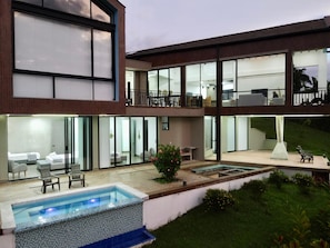 A modern two-story building with a swimming pool, outdoor seating, and a well-maintained garden. - Villa with infinity pool and 180° views Filandia (Filandia)