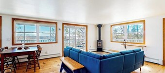 Dog-friendly river-view home with wood stove, deck, patio, dock, beach, grill
