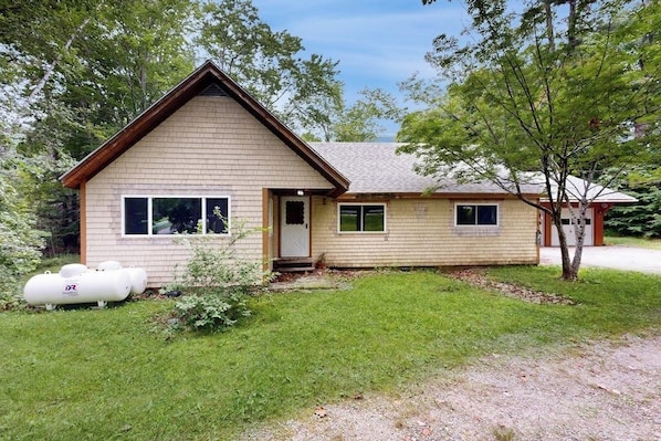 A single-story house with a gabled roof, a front porch, and a small front yard.
