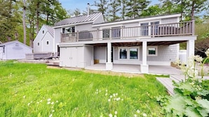 Een tweelaags huis met een balkon, een overdekte veranda en een garage.