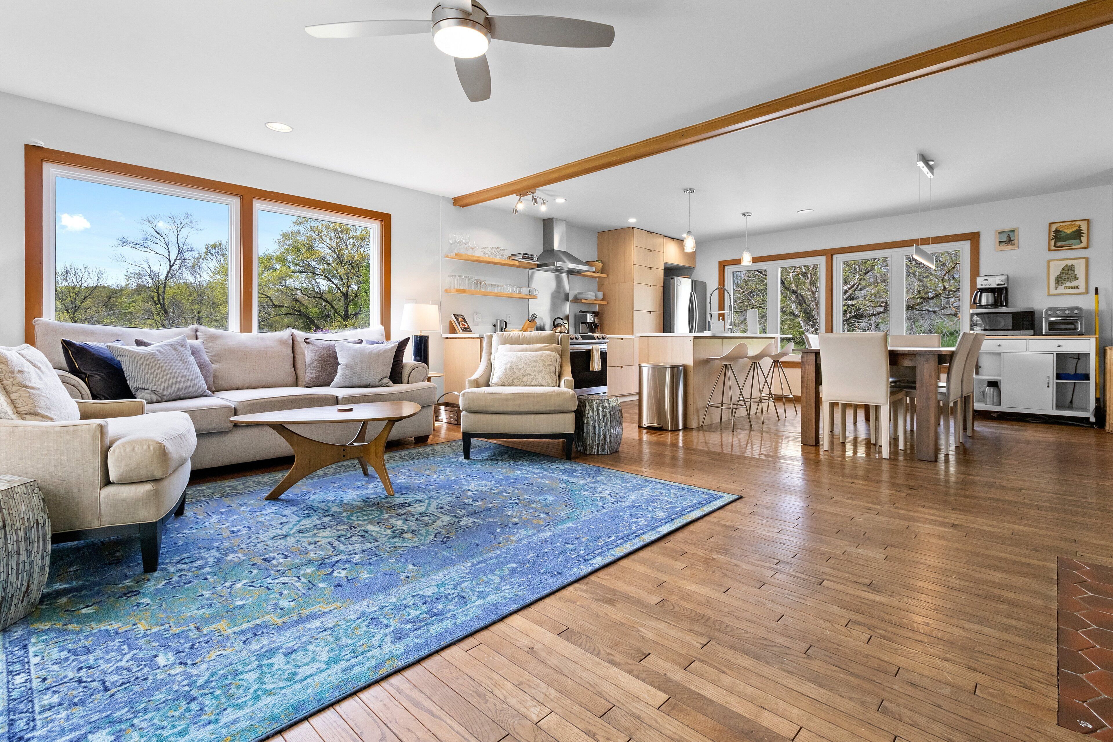 A spacious living area with a large sofa, a coffee table, and a blue patterned rug.
