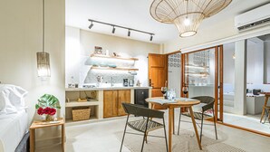 A modern kitchen with a dining area, a small table with chairs, and a large window. - spectacular apartasuit in hotelb outique (Santa Marta)