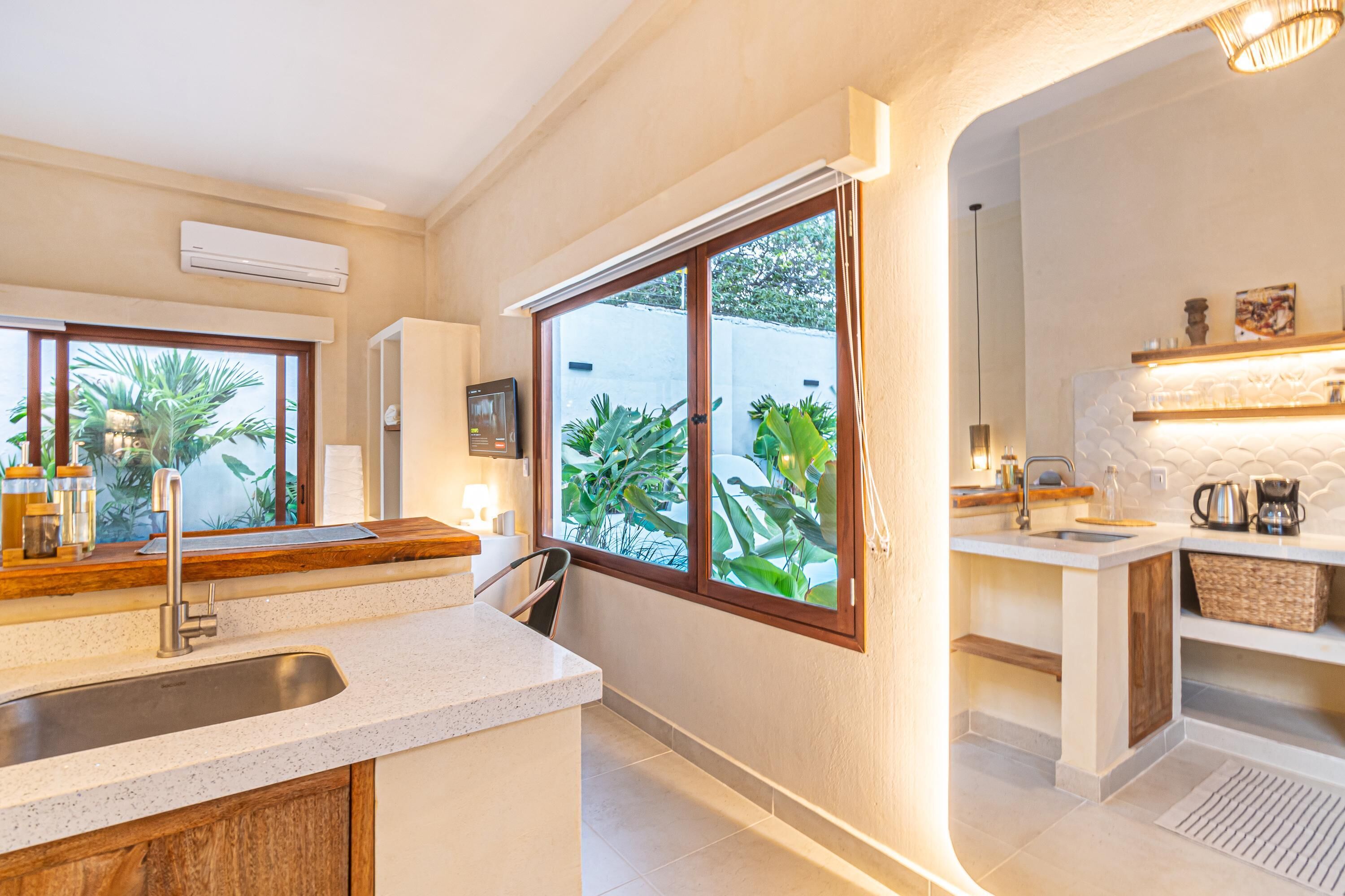 A modern kitchen with a large window, a built-in sink, and a countertop.
