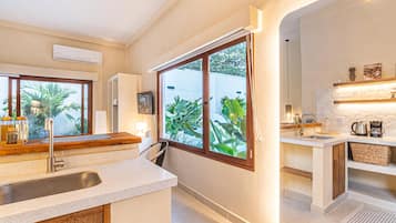 A modern kitchen with a large window, a built-in sink, and a countertop.