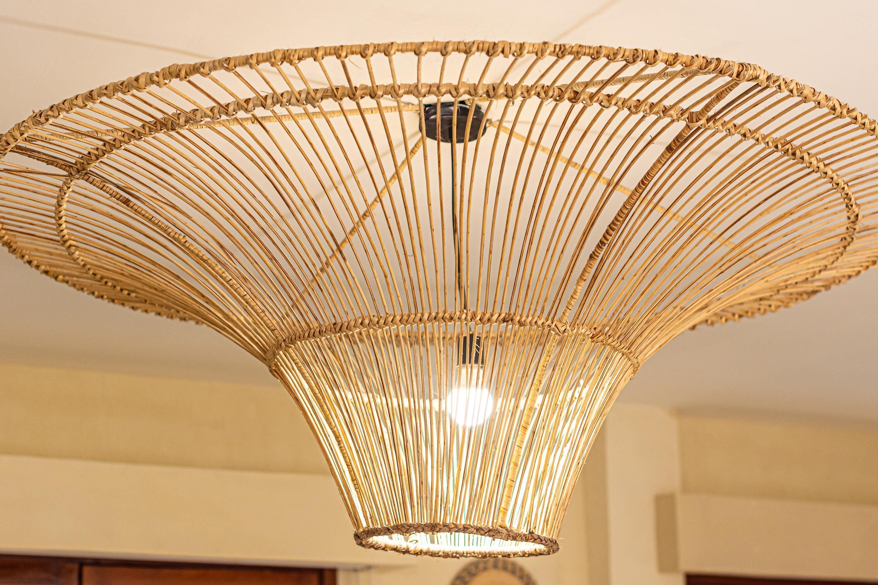 A woven, gold-colored ceiling light fixture with a central bulb.