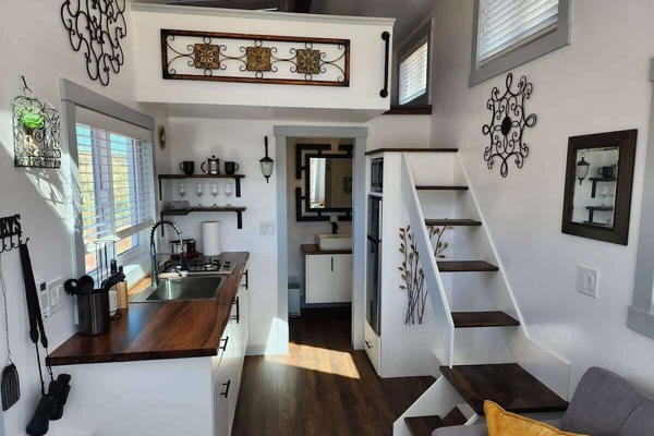 Modern kitchen featuring a two-burner cooktop, microwave, refrigerator with freezer, and smart storage. Designed to maximize space while providing everything needed for a comfortable and convenient stay.