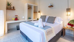 Een moderne hotelkamer met een groot bed, nachtkastjes, een spiegel en een kleine plant.