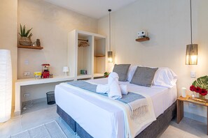 A modern hotel room with a large bed, bedside tables, a mirror, and a small plant. - Apartasiote with pool views (Santa Marta)