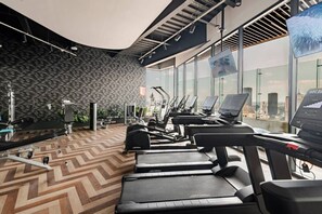 Ein Fitnessstudio mit Laufbändern, Crosstrainern und Gewichten.