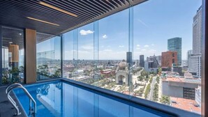 Une piscine intérieure moderne offrant une vue sur la ville.