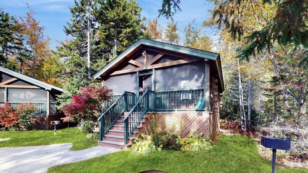 A cabin with a porch, stairs, and a mailbox. - Charming dog-friendly studio cabin with firepit and outdoor activities (Northport)