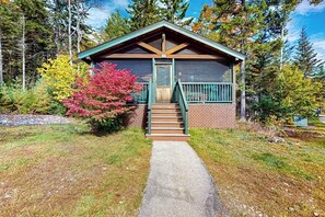 Eine kleine Holzhütte mit einer Veranda und einer Treppe zum Eingang.