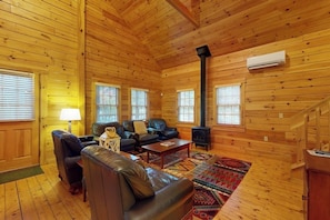 A log cabin interior with a fireplace, leather furniture, and a patterned rug. - Tranquil dog-friendly cabin with full kitchen, fireplace & nearby recreation (Northport)