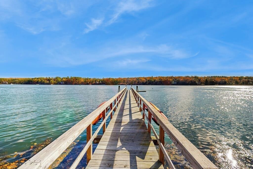 A wooden pier extending into a body of water with a clear sky above.