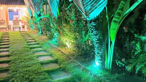 A garden with a hammock, a pathway, and a building with a tiled roof. - Beautiful Leisure House (Trancoso)