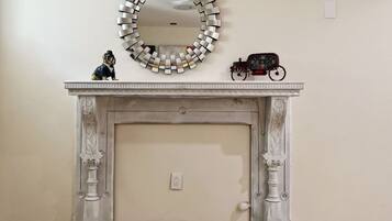 A fireplace with a decorative mirror above it and a toy train on the mantel.