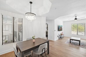 Un vaste espace dédié à la salle à manger, agrémenté d’un lustre, d’une table et de chaises.