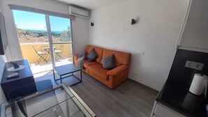 Un espace de vie moderne comprenant un canapé, une table en verre et une vue sur l’extérieur.