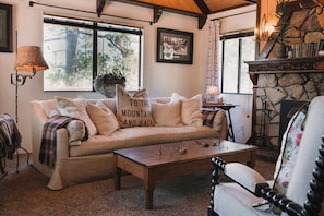 Una sala de estar acogedora con un sofá, una mesa de centro y una chimenea.