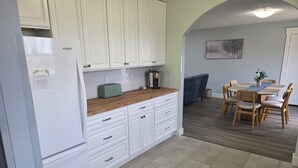 A kitchen with white cabinets, a toaster, and a coffee maker on the counter.