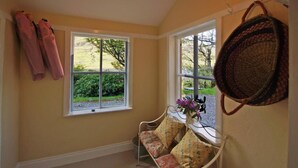 A room with a bench, two windows, and a basket on the wall. - 4 Bed in Renvyle (oc-i258) (Illaunroe)