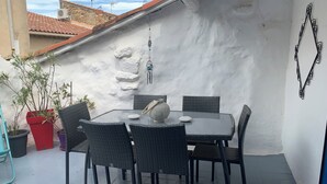 A rooftop patio with a table and chairs, potted plants, and a decorative wall. - The daring home between sea and mountains perfect for family vacations (Cazouls-lès-Béziers)