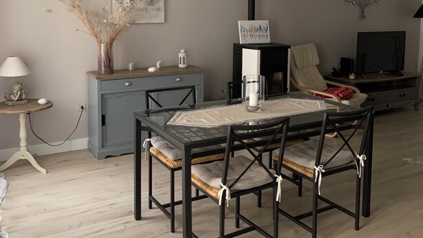 A dining area with a glass-top table, black chairs, a blue cabinet, and a hanging light fixture. - The daring home between sea and mountains perfect for family vacations (Cazouls-lès-Béziers)