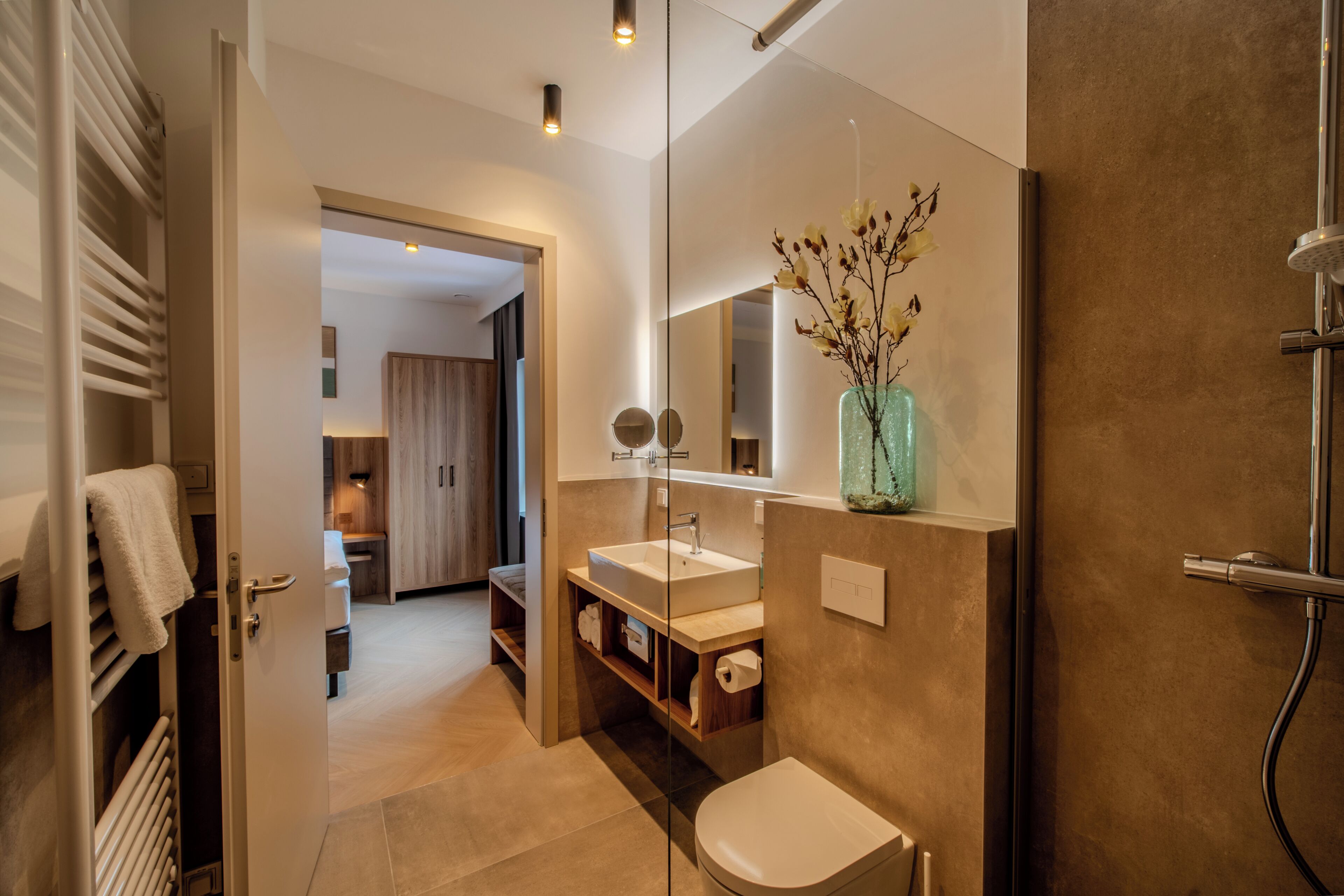 Ein modernes Badezimmer mit großem Spiegel, Waschbecken und Toilette.