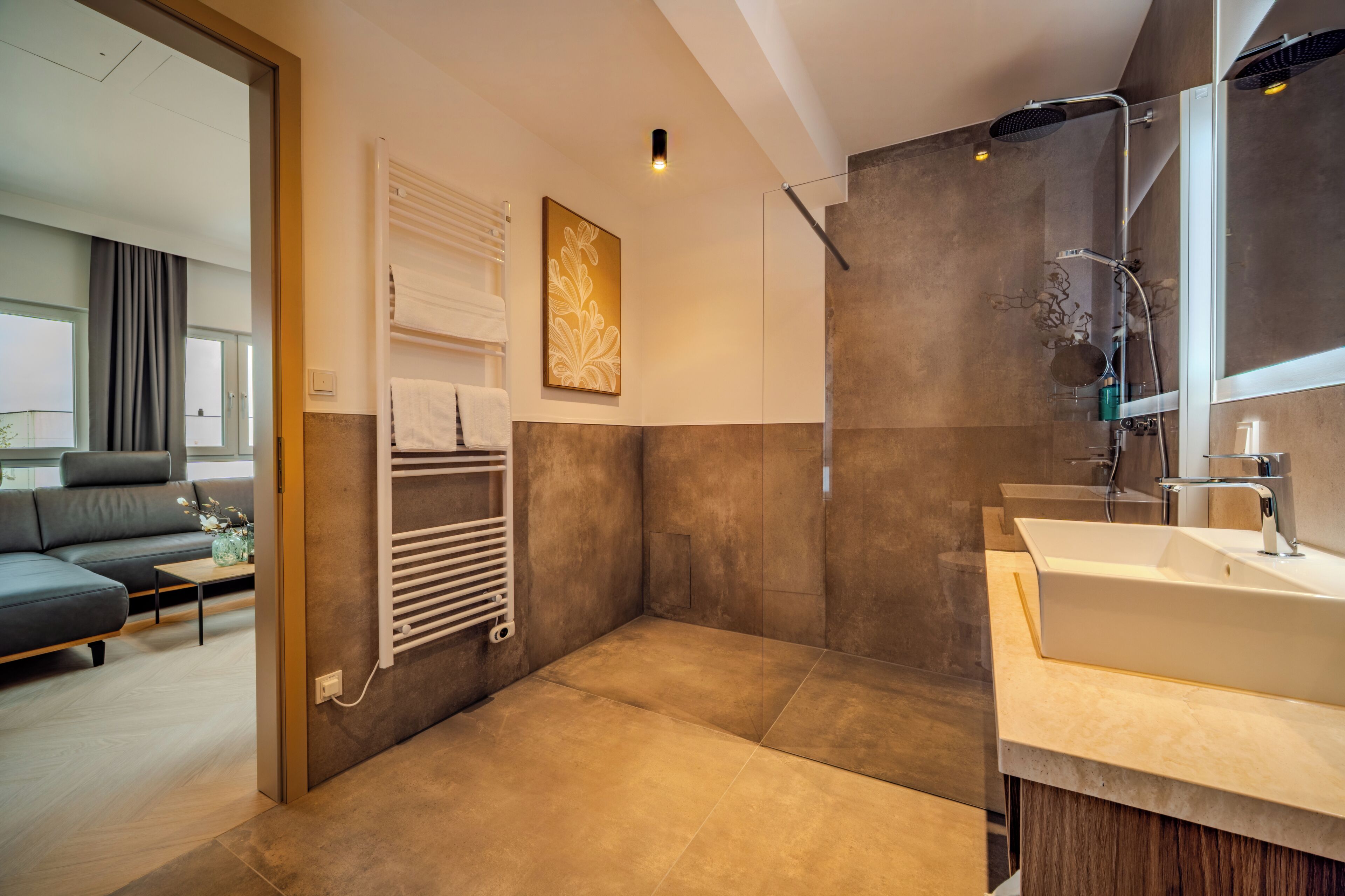 Un baño moderno con un lavamanos grande, ducha y toallero.