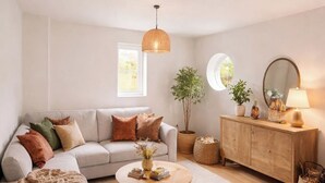 Ein Wohnzimmer mit Sofa, Couchtisch, Holzschrank und Topfpflanzen.