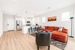 A modern apartment with a kitchen, dining area, and living room. - IRIE Living-Haven 2BR Home with Pool Gym Access (Whitestown)