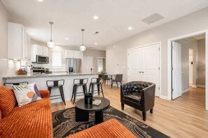 A modern apartment with a kitchen, dining area, and living room. - IRIE Living-Serene Kg 2Bd Gym Pool, NEW! (Whitestown)