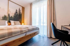 Ein Schlafzimmer mit einem Bett, einem Schreibtisch und einem Stuhl.