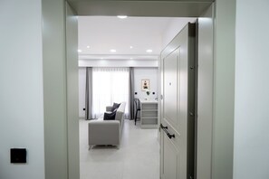 A modern hotel room with a sofa, a desk, and a wardrobe. - Ayayorgi Residence Cesme (Çeşme)
