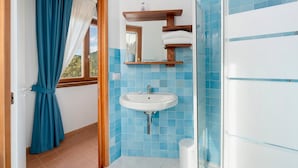 Un baño con lavamanos, espejo y azulejos azules.
