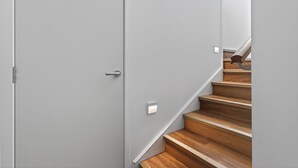 Un escalier moderne avec des marches en bois et un mur gris.