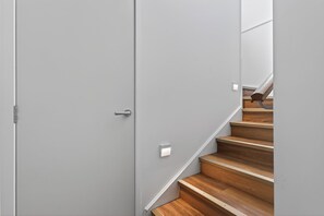 Eine moderne Treppe mit Holzboden und grauer Wand.