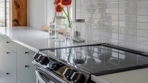 Una cocina con estufa, horno y ventana con vistas.