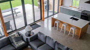 Un interior moderno con un ventanal grande, una isla de cocina y una zona de estar.