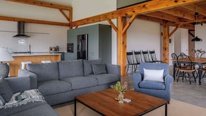 Una sala de estar moderna con un sofá gris, una mesa de centro de madera y un comedor con sillas de madera.