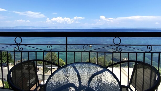 A balcony with a clear view of the sea and distant mountains. - El Greco Hotel (Corfu)