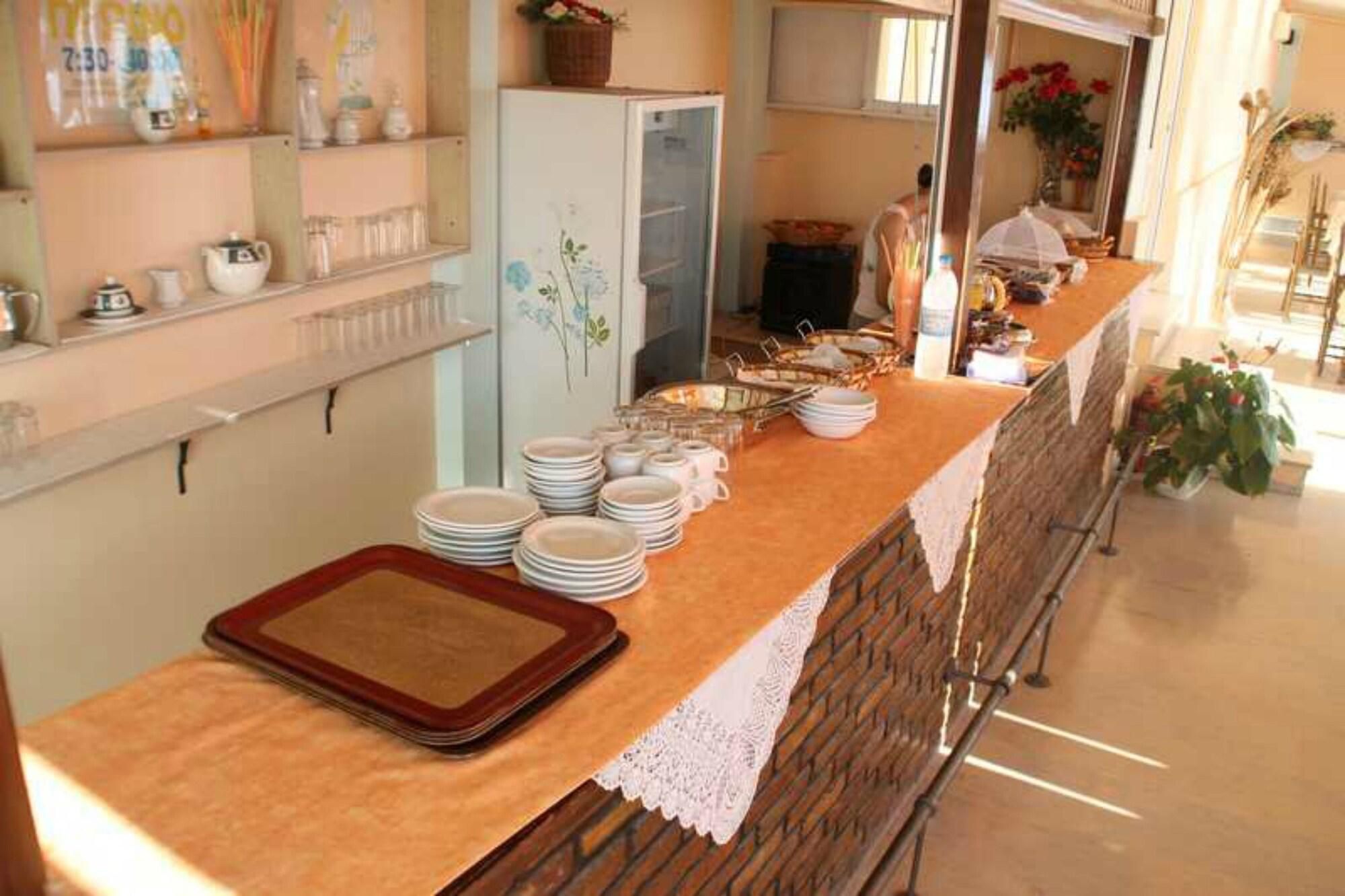 A breakfast buffet setup with plates, bowls, and a tray on a counter.