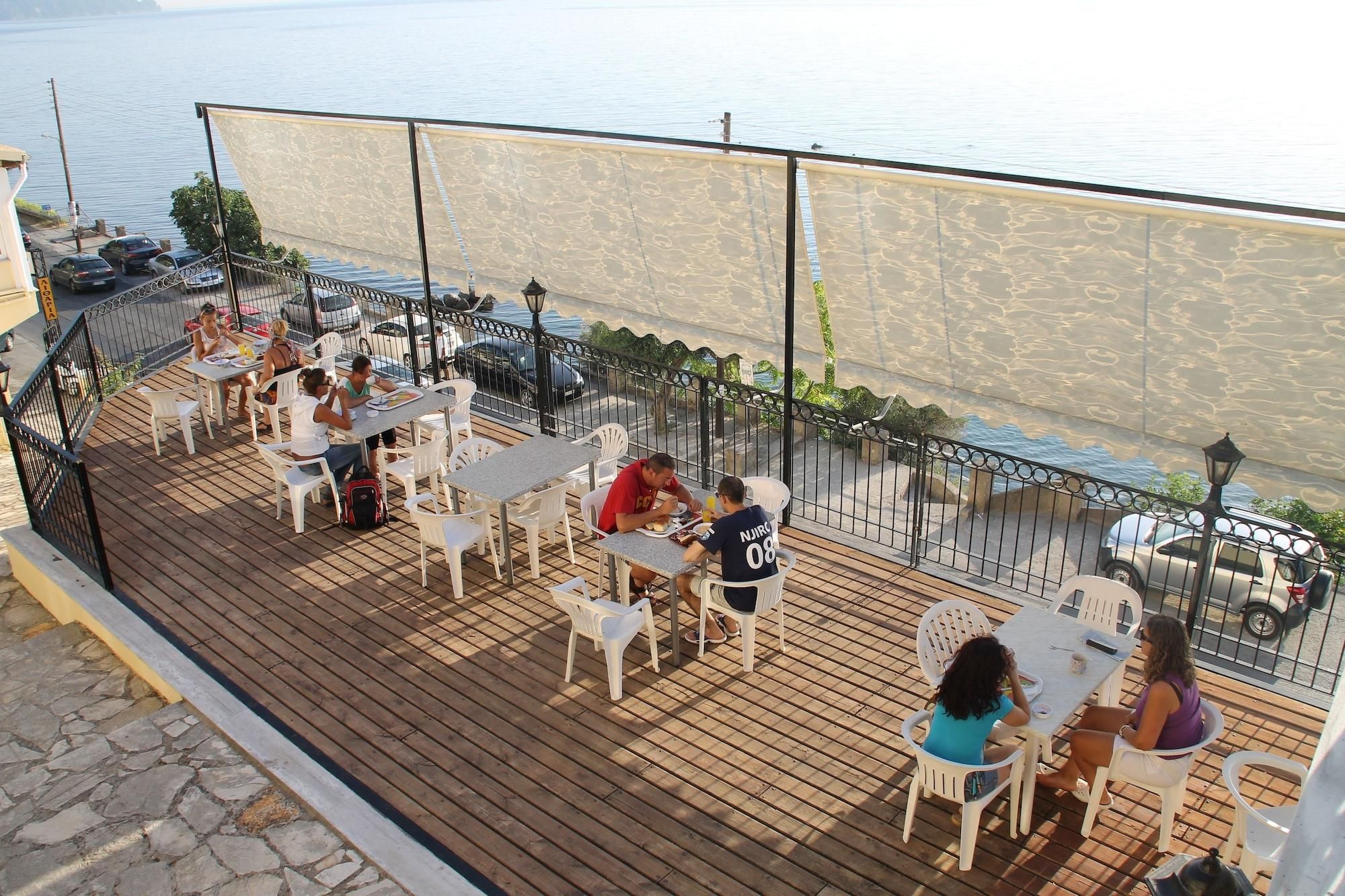 A deck with tables and chairs, overlooking a body of water.