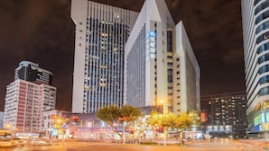 Un hotel moderno dall'architettura originale e dalle linee geometriche, su più piani, con insegne illuminate.